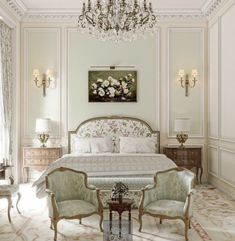 an elegant bedroom with chandelier and white walls