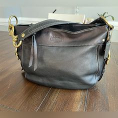 Coach Zoe Shoulder Bag M1020-F12671 Genuine Soft Leather. Black With Dark Brown Trim (Top) Brass Tone Hardware Measures 12” X 9.5” Shoulder Drop 6” Zip Closure. Zip & Side Pockets Inside Scratches To The Loop Hardware, Minor Wear To The Leather (Pic) In Excellent Condition Beautiful Bag. Everyday Crossbody Bucket Bag With Branded Hardware, Crossbody Bucket Bag With Branded Hardware For Everyday Use, Crossbody Bucket Bag With Branded Hardware, Everyday Bucket Shoulder Bag With Branded Hardware, Coach Bags With Gunmetal Hardware For Everyday, Coach Bucket Shoulder Bag With Branded Hardware, Everyday Coach Bags With Gunmetal Hardware, Satchel Hobo Bag With Branded Hardware For Everyday Use, Hobo Satchel Bag With Branded Hardware For Everyday Use