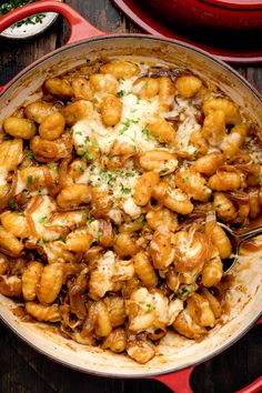 a skillet filled with chicken and cheese on top of a wooden table