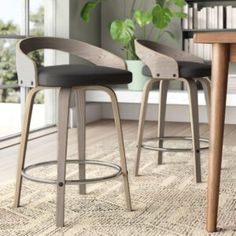 two modern bar stools in front of a dining room table and bookshelf