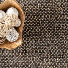 some white balls in a wooden bowl on a carpet