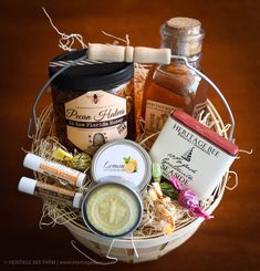 a basket filled with honey, jams and condiments on top of a wooden table