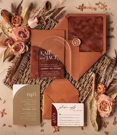 the wedding stationery is laid out with flowers, feathers and other things to put on it