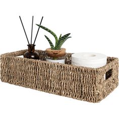 a wicker basket with two plants and toiletries in it on a white background