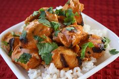 chicken with cilantro and parsley on top of rice in a white bowl