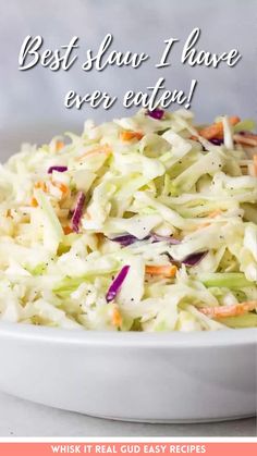 a white bowl filled with coleslaw and carrots on top of a table