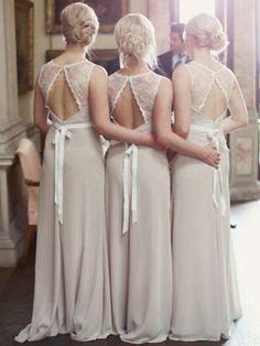 three bridesmaids in long dresses looking at each other with their back to the camera