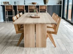 a large wooden table with chairs around it in a room that has wood flooring