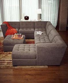 a living room with a large gray couch and coffee table in front of a window