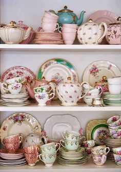 a shelf filled with lots of china and dishes on top of eachother's shelves