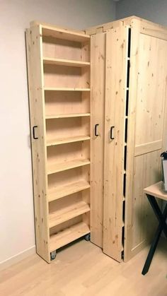 an empty room with two wooden shelves and a desk in the corner next to it