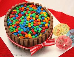 there is a chocolate cake with candy in the middle and an umbrella next to it