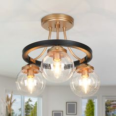 three clear globes are hanging from the ceiling in this modern style chandelier