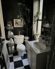 a bathroom with black and white checkered flooring is pictured in this image, there are plants growing on the wall next to the toilet