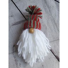 a white and red striped hat with tassels on it's head sitting on a tile floor