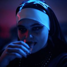 a woman with a bandana on her head is brushing her teeth in the dark