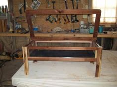 a bed frame sitting on top of a wooden platform in a room filled with tools