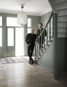 two men standing on the stairs in an empty house