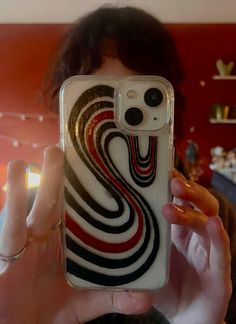 a woman taking a selfie in front of her phone case with the design on it