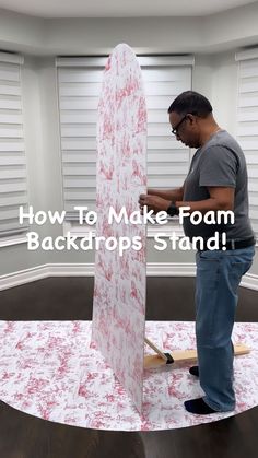 a man standing next to a white surfboard on top of a wooden floor with the words how to make foam backdrop stand