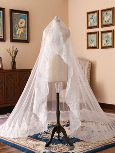 a white wedding veil sitting on top of a mannequin in a living room