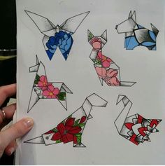 a person holding up a piece of paper with some origami animals on it