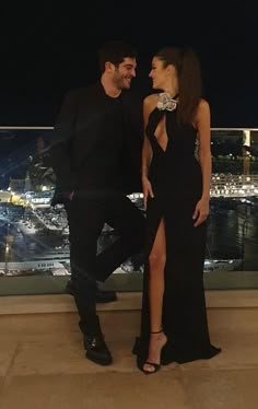 a man and woman standing next to each other in front of a cityscape