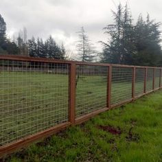 a wooden fence in the middle of a grassy field