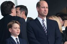 a man in a suit and tie standing next to a little boy