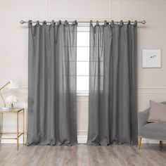 a living room with grey curtains and a chair