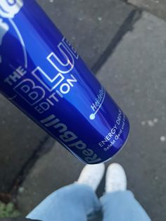 a close up of a person's feet holding a blue cup