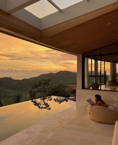 a woman sitting on top of a bean bag chair next to a swimming pool at sunset