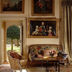 a living room filled with furniture and paintings on the wall