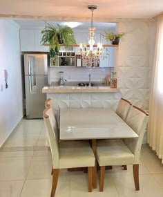 a kitchen table with four chairs and a refrigerator in the backgroung area