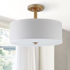 a white lamp hanging from the ceiling in a living room