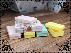 several different colored boxes sitting on top of a wooden table