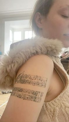 a woman with a musical note tattoo on her arm