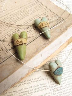 three small green and blue beads on top of an old book