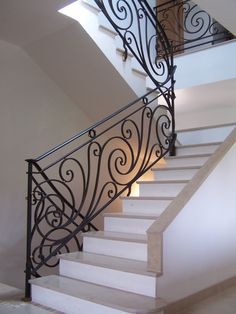 a stair case with wrought iron railing and handrail