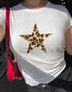 Adorable Leopard Print Star Baby Tee! This comfy, aesthetic shirt captures the best of the 90s and Y2K styles, making it a perfect gift for yourself or a friend. Ideal for teenage girls, it's great for a 16th birthday celebration, or as a trendy graphic shirt from an aunt to her niece. A must-have for any teen girl's wardrobe! This shirt is made from a 100% cotton Gildan 5000B youth t-shirt, designed to fit like a classic 90s or Y2K baby tee. Be sure to consult the size chart and compare it to one of your own shirts to ensure you get that perfect fitted look. While colors may vary slightly between your screen and the actual product, you can expect rich hues and a clear design. The shirt features no side seams and has a tear-away label for a comfortable, scratch-free experience. Your satisf Baby Tees Y2k, Y2k Baby Tee, Teenage Girl Gifts, Aesthetic Shirts, Baby T Shirts, Girls Wardrobe, Y2k Style, Star Shirt, Baby Star