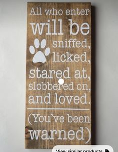 a wooden sign with a dog's paw on it