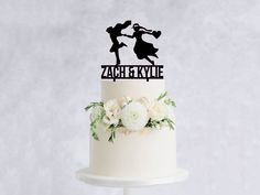 a wedding cake with a silhouette of two people on top