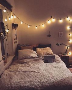 a bedroom with lights strung above the bed