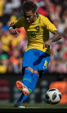 a man kicking a soccer ball on top of a field