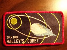 a patch that says, july 2006 halley's comet on the side of a wooden table