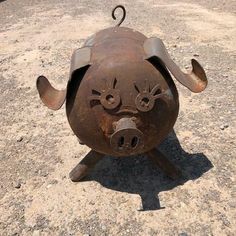 a metal pig head sitting on top of a cement ground