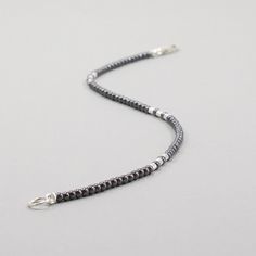 This delicate hematite bracelet is accented with sterling silver tube beads. The beads are tiny 2mm hematite beads. The clasp is a secure lobster claw. This minimalist bracelet can be worn alone or layered with your other gemstone bracelets. This dainty bracelet is made of 2mm beads, see pictures to see the scale of the beads. 2mm round hematite beads 2mm tube beads lobster claw clasp and oversized ring for easy clasping strung on cord for durability and a soft drape choose your bracelet length Silver Hematite Bracelets With Faceted Beads, Silver Hematite Bracelet With Faceted Beads, Oversized Ring, 2mm Beads, Handmade Boho Jewelry, Lapis Lazuli Bracelet, Hematite Bracelet, Tourmaline Bracelet, Dainty Bracelet