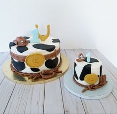 two decorated cakes sitting on top of a wooden table