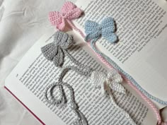 three crocheted bows on top of an open book