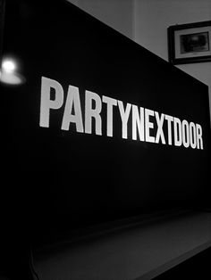 the party next door sign is lit up in black and white with light on it